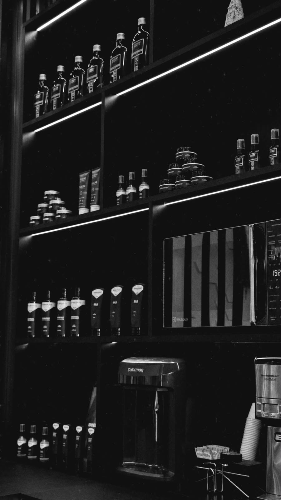 Parede de produtos e cuidados masculinos em tom escuro