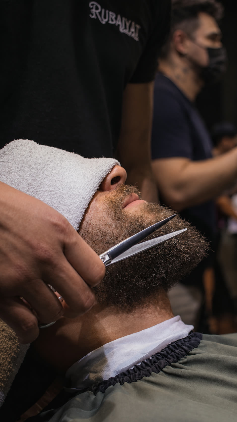 Barbeiro fazendo acabamento da barba com navalha